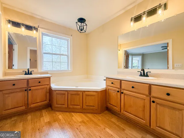 a spacious bathroom with a tub sink and mirror