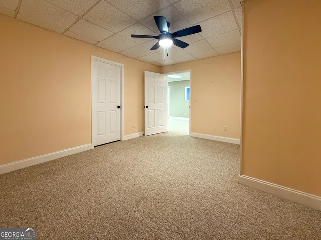 an empty room with chandelier fan