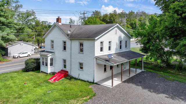 a view of a house with a yard and sitting area