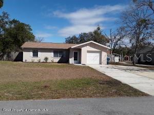 1428 Gold Road Spring Hill, FL 34609 - Photo 1 of 1 a front view of a house with a yard and garage