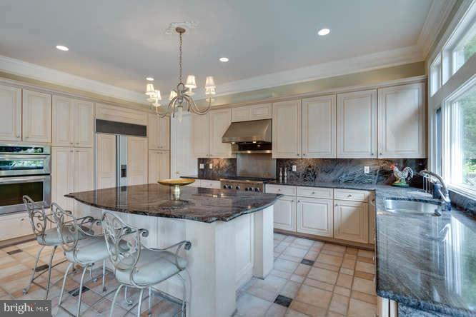 1193 Windrock Drive McLean, VA 22102 - Photo 16 of 30 a kitchen with kitchen island granite countertop a sink a counter top space appliances and cabinets