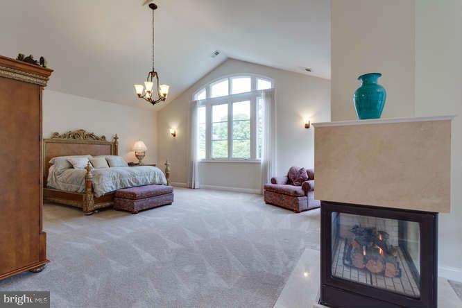 1193 Windrock Drive McLean, VA 22102 - Photo 21 of 30 a spacious bedroom with a bed and a chandelier