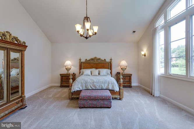 1193 Windrock Drive McLean, VA 22102 - Photo 22 of 30 a spacious bedroom with a bed and a chandelier
