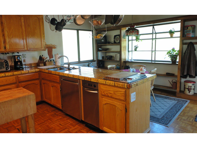 9970 Burchell Road Gilroy, CA 95020 - Photo 8 of 11 a kitchen with stainless steel appliances granite countertop a sink dishwasher a stove a dining table and chairs with wooden floor