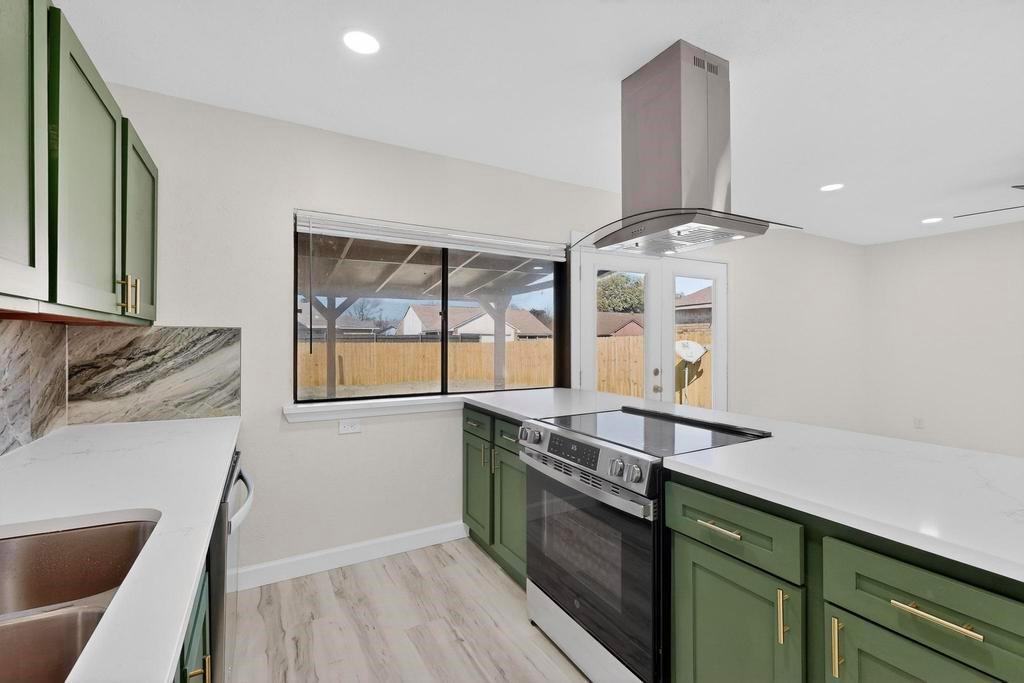 8505 Woodside Road Rowlett, TX 75088 - Photo 14 of 40 a kitchen with stainless steel appliances granite countertop a stove and a sink
