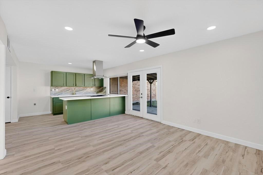 8505 Woodside Road Rowlett, TX 75088 - Photo 17 of 40 a kitchen with kitchen island a sink dishwasher a stove and white cabinets with wooden floor