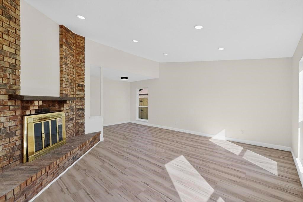 8505 Woodside Road Rowlett, TX 75088 - Photo 7 of 40 a view of an empty room with wooden floor and a window