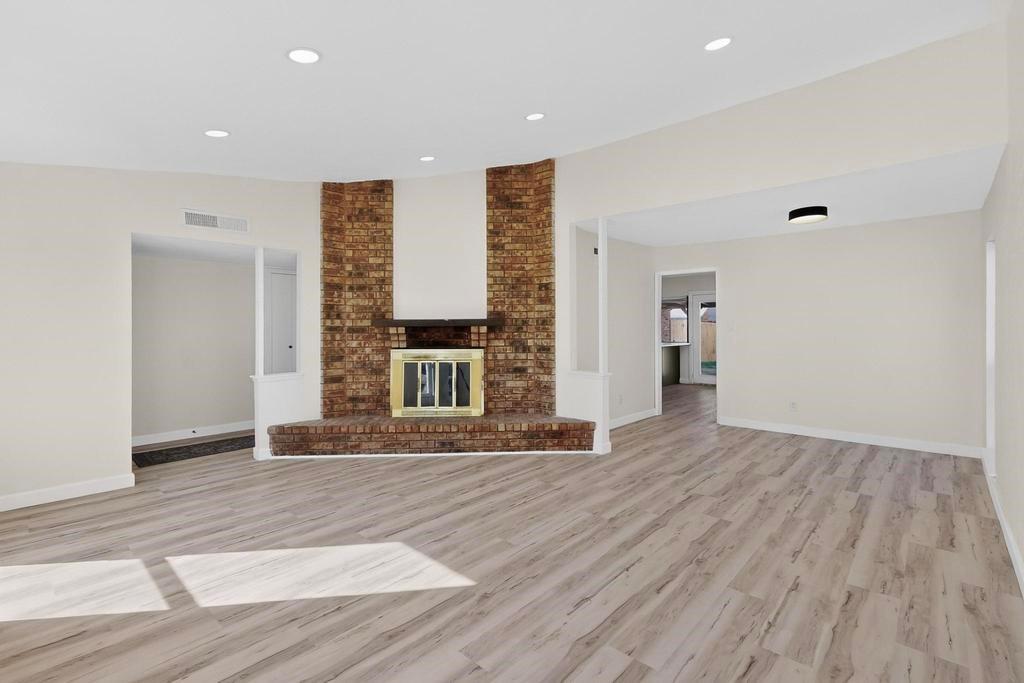 8505 Woodside Road Rowlett, TX 75088 - Photo 8 of 40 a view of an empty room with wooden floor and a window