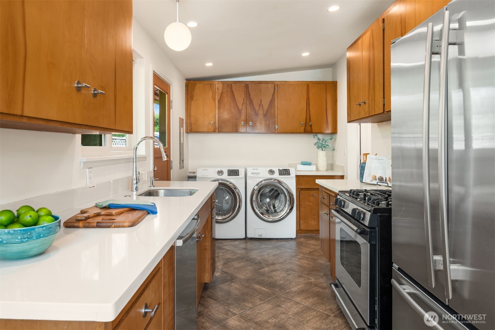 4714 50th Avenue Southwest Seattle, WA 98116 - Photo 17 of 34 a kitchen with stainless steel appliances granite countertop a sink a stove and a refrigerator