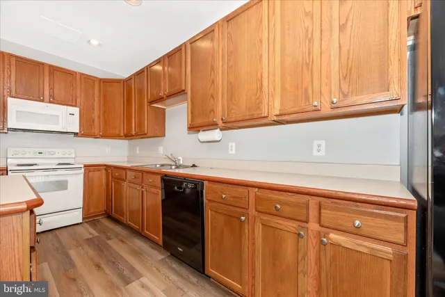 a kitchen with stainless steel appliances granite countertop a sink a stove a refrigerator and cabinets