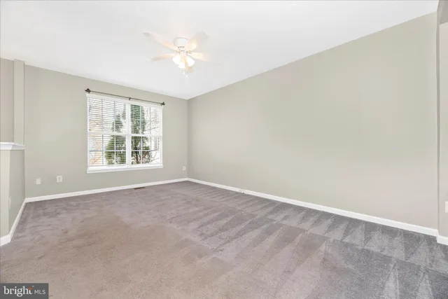 a view of an empty room with a ceiling fan
