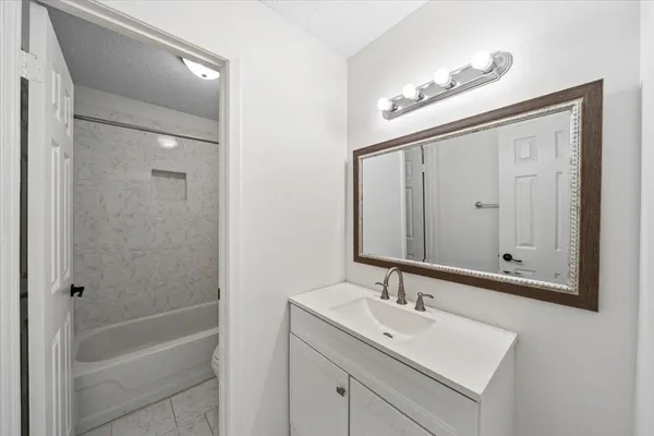 a bathroom with a bathtub a sink and mirror