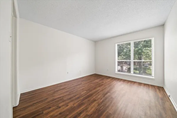 a view of an empty room with wooden floor