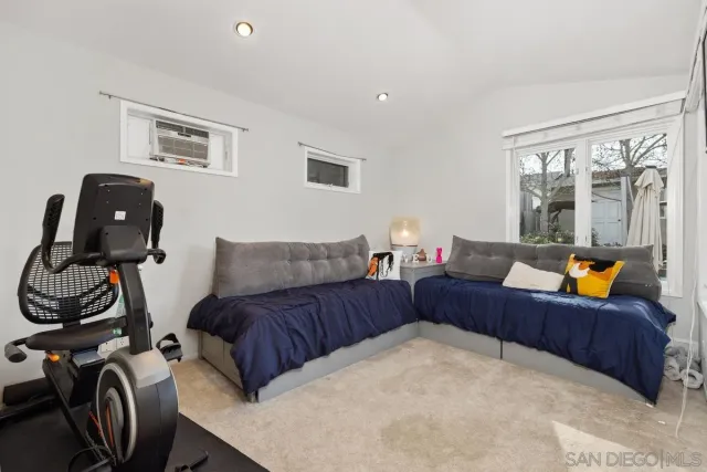 a living room with furniture a large window and gym equipment
