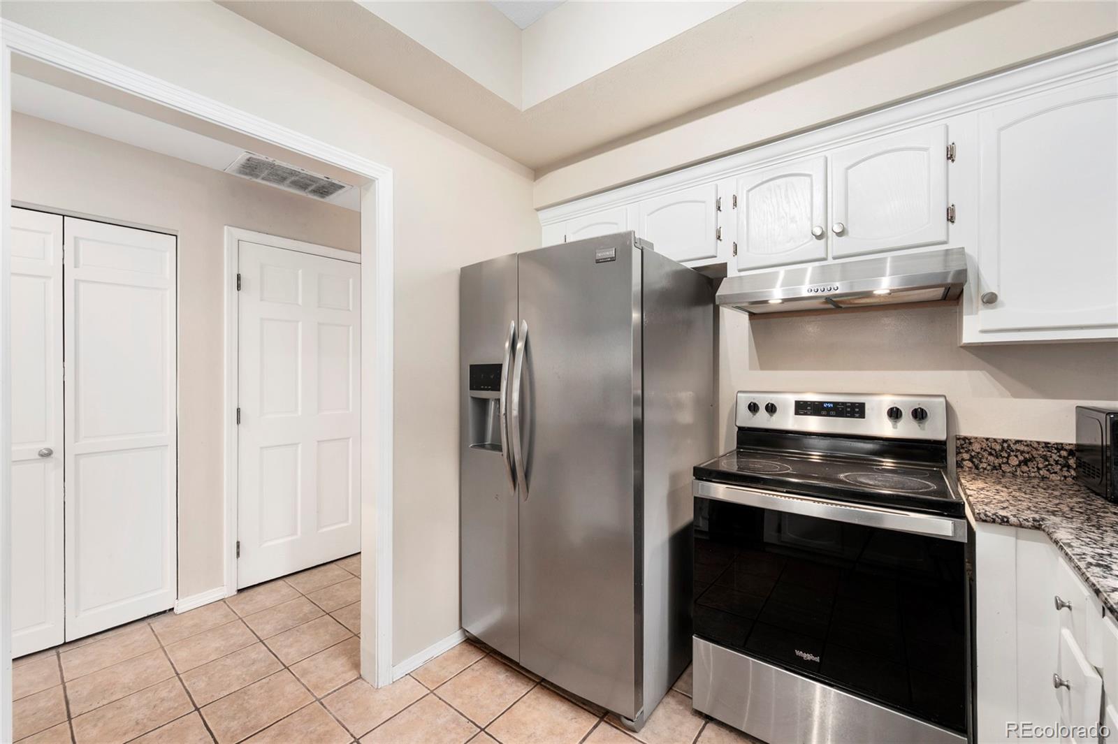 1512 Larimer Street, Unit 21 Denver, CO 80202 - Photo 1 of 18 a kitchen with stainless steel appliances a stove a refrigerator and cabinets