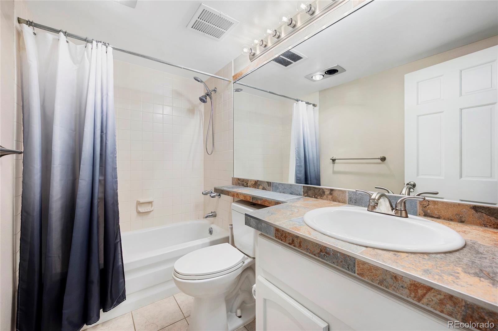1512 Larimer Street, Unit 21 Denver, CO 80202 - Photo 13 of 18 a bathroom with a granite countertop sink toilet and shower