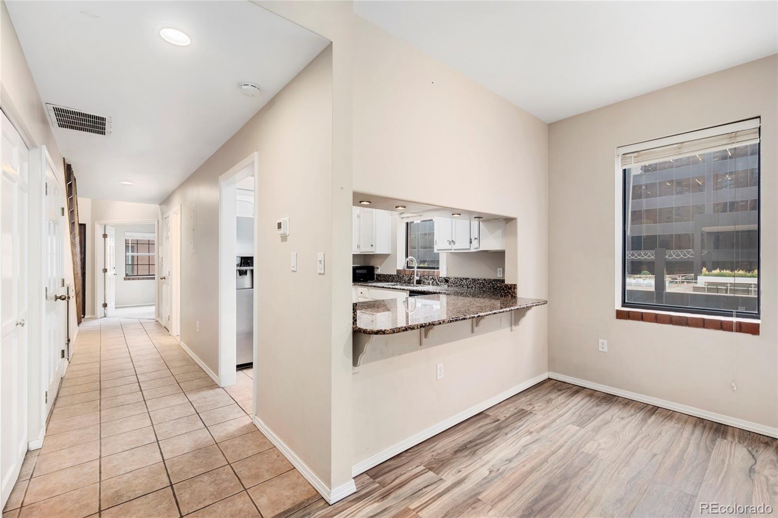 1512 Larimer Street, Unit 21 Denver, CO 80202 - Photo 14 of 18 a kitchen with stainless steel appliances granite countertop a refrigerator and a stove top oven