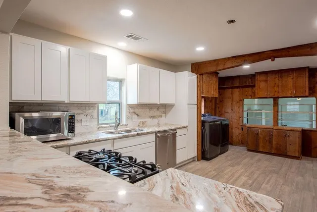 a kitchen with a refrigerator and a stove top oven