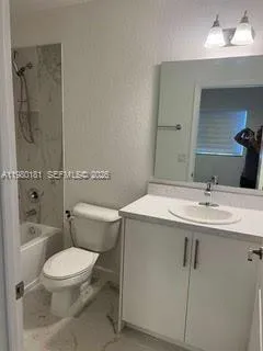 a white bath tub sitting next to a white toilet and a shower