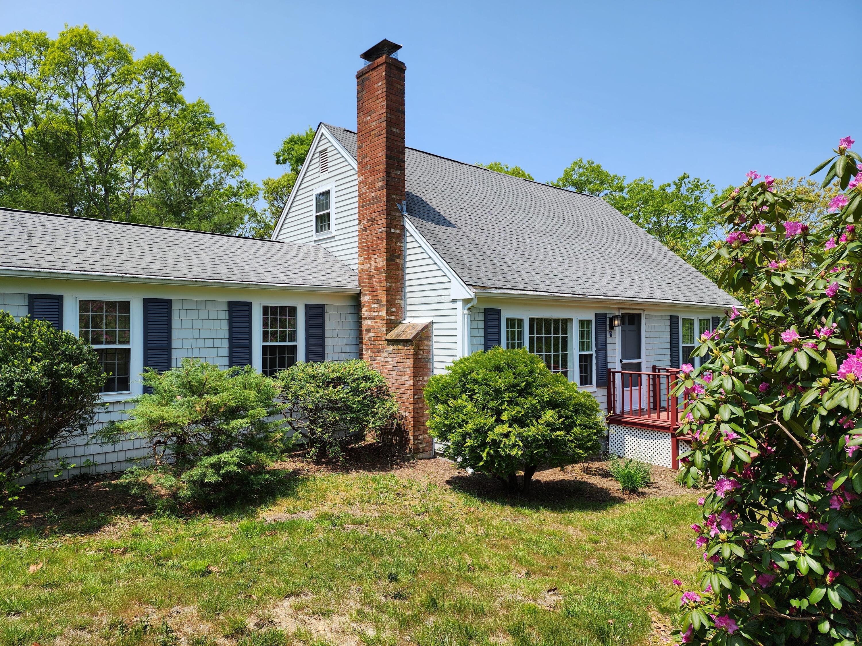 a front view of a house with a yard and potted plants