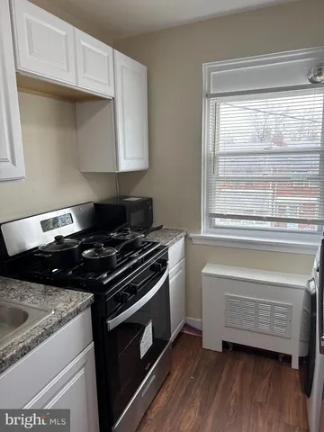 a kitchen with wooden floor and a stove top oven