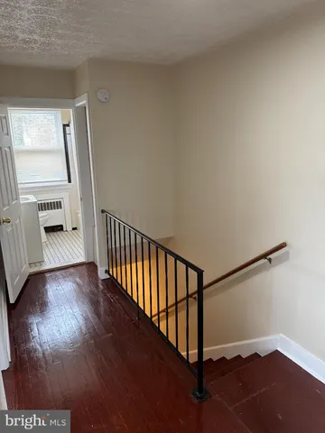 a view of a hallway with wooden floor and stairs