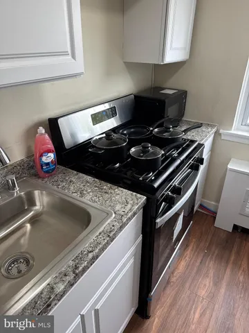 a bedroom with a bed and a lamp on dresser