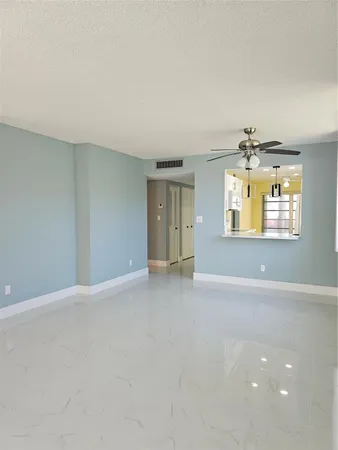 an empty room with a windows and chandelier