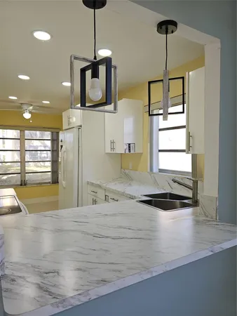 a kitchen with kitchen island a window a sink and a refrigerator