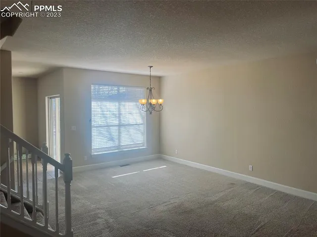 a view of a hallway to rooms and stairs