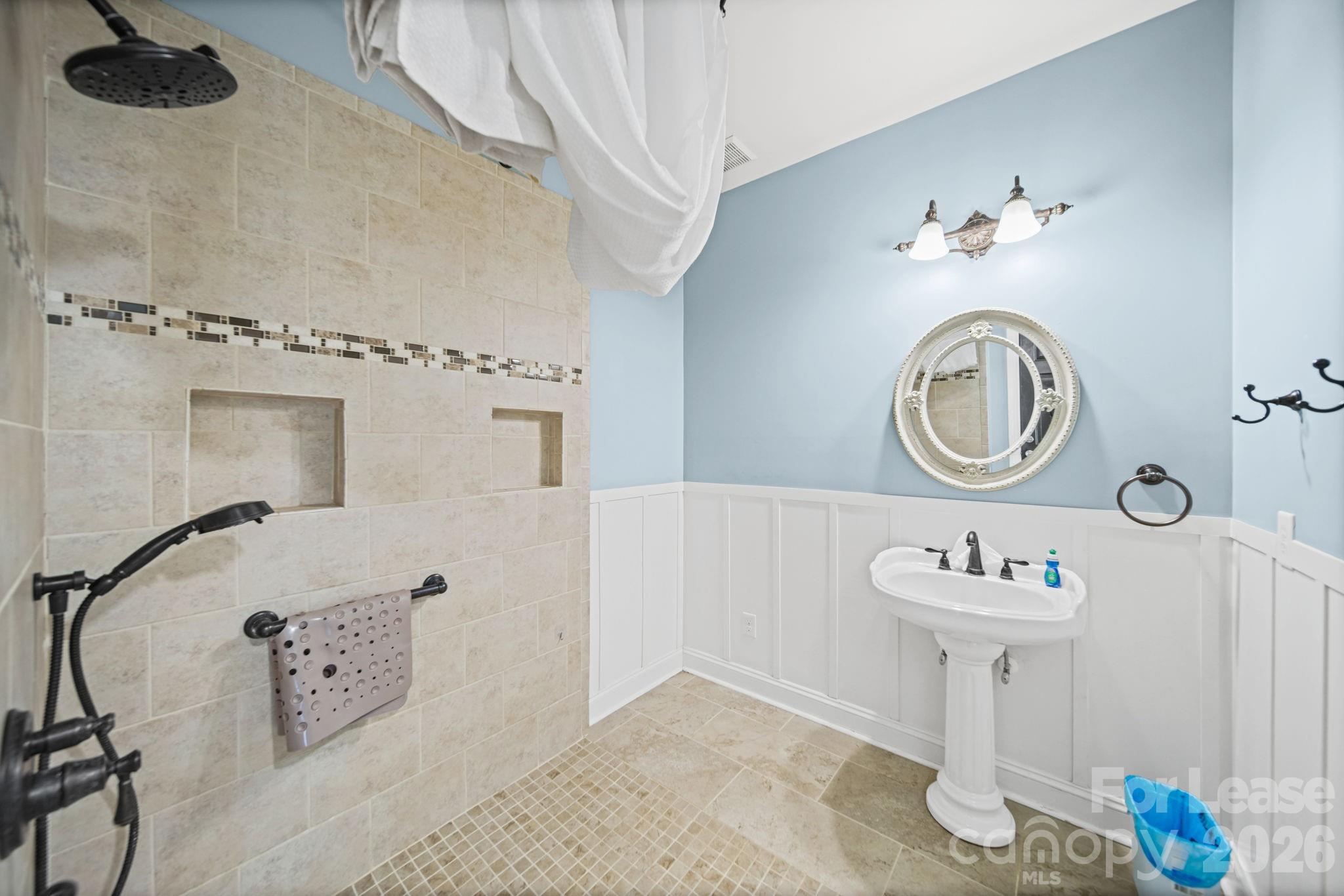 7107 Nesbit Road Waxhaw, NC 28173 - Photo 23 of 42 a bathroom with a sink a mirror and a shower