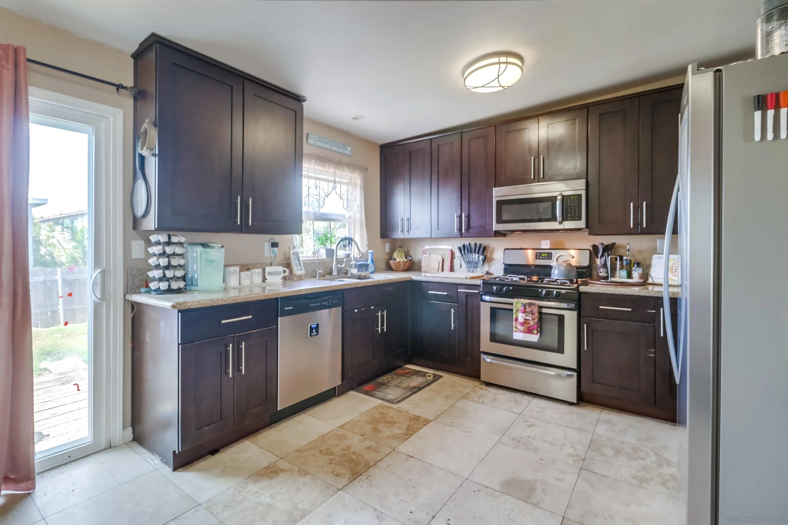 9833 St George Street Spring Valley, CA 91977 - Photo 7 of 19 a kitchen with stainless steel appliances granite countertop a refrigerator stove top oven a sink and dishwasher