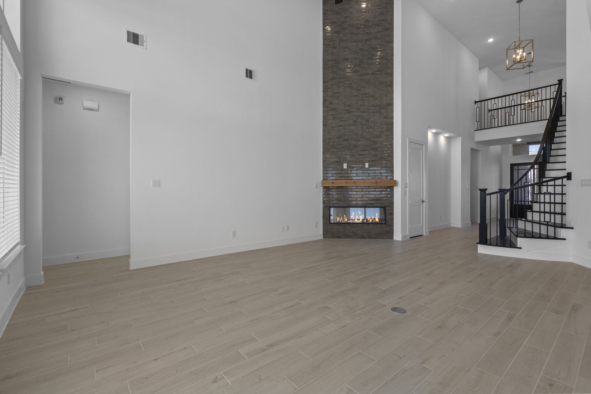 9103 Basilica Lane Manvel, TX 77578 - Photo 11 of 50 an empty room with a fireplace and a chandelier fan