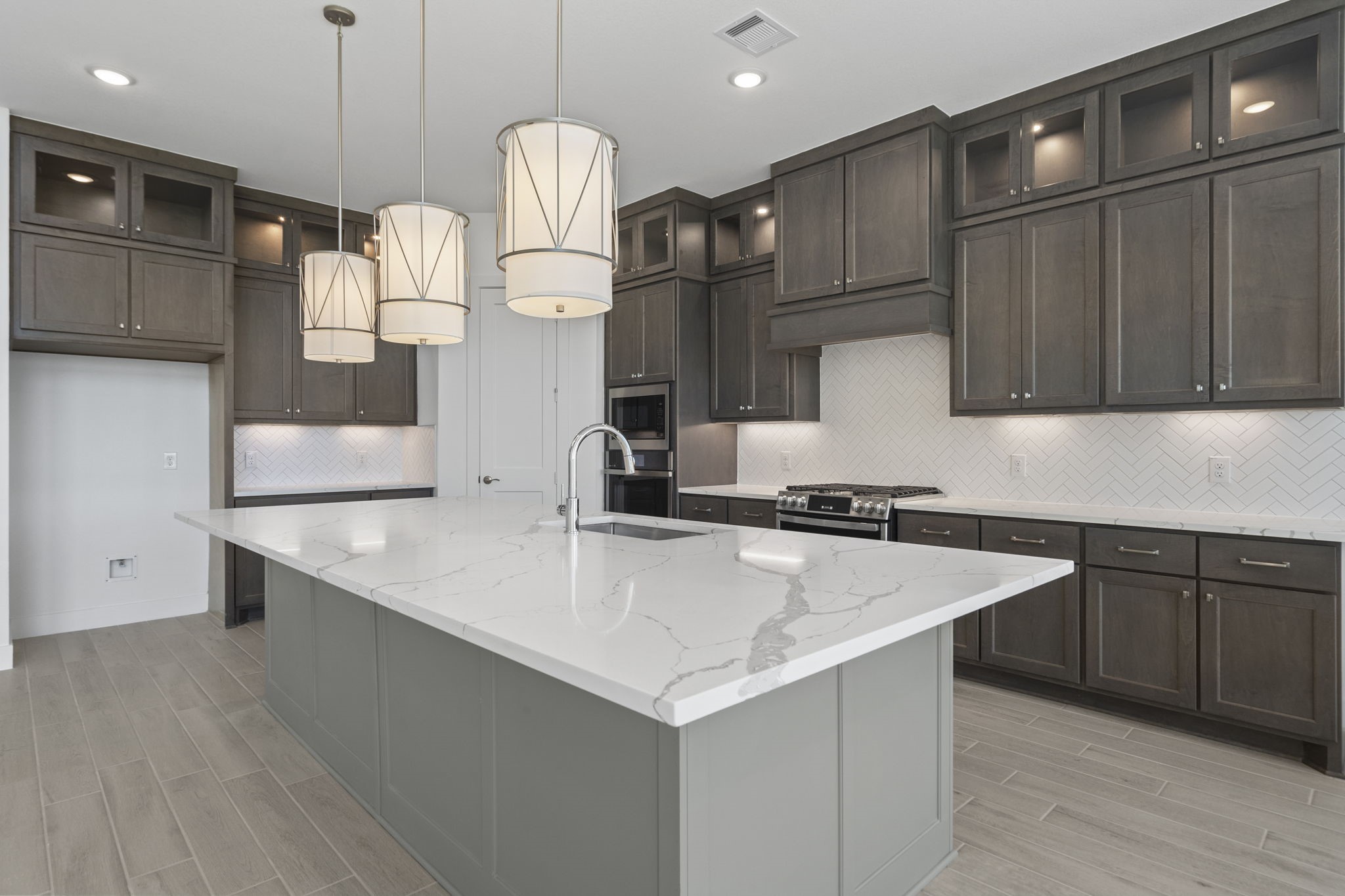 9103 Basilica Lane Manvel, TX 77578 - Photo 4 of 50 a kitchen with a sink cabinets and wooden floor