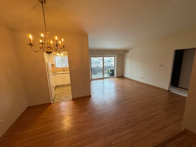 a view of a room with wooden floor and chandelier