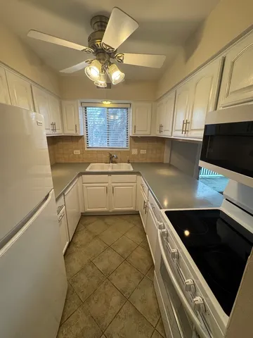 a kitchen with a sink a stove and cabinets