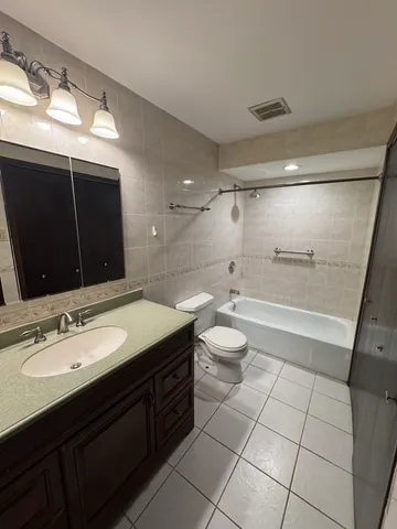 a bathroom with a sink a toilet a mirror and shower