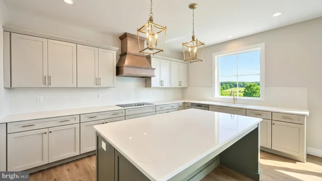 a kitchen with white cabinets and window