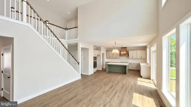 a view of an empty room with wooden floor fireplace and a window