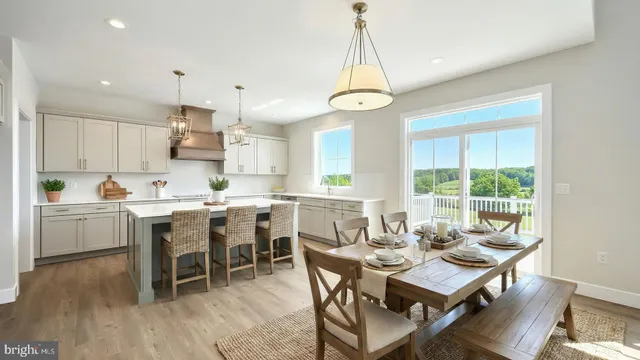 a view of a dining room and livingroom with furniture wooden floor a chandelier