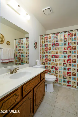 a bathroom with a sink a toilet and shower curtain