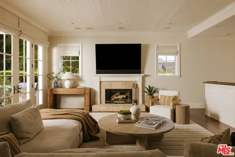 a living room with furniture a flat screen tv and a fireplace