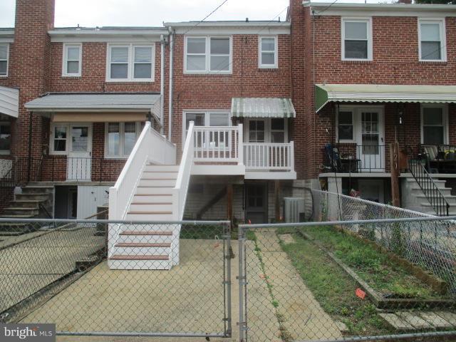 122 Hampshire Road Baltimore, MD 21221 - Photo 21 of 22 a view of a brick house with large windows and a small yard