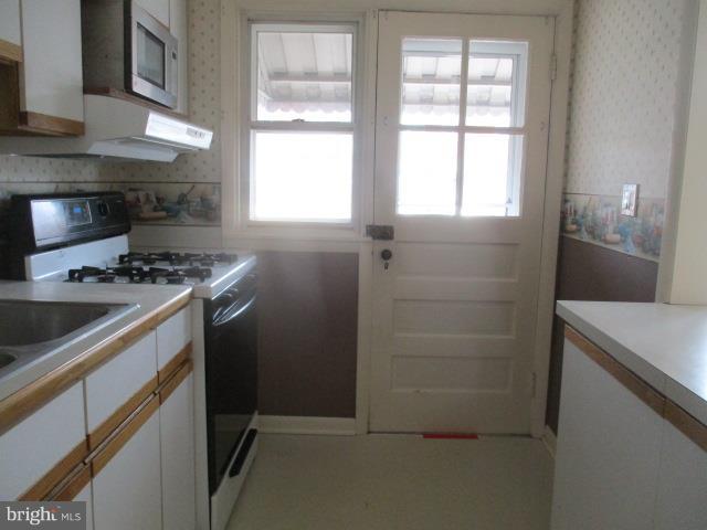 122 Hampshire Road Baltimore, MD 21221 - Photo 8 of 22 a kitchen that has a stove and a refrigerator