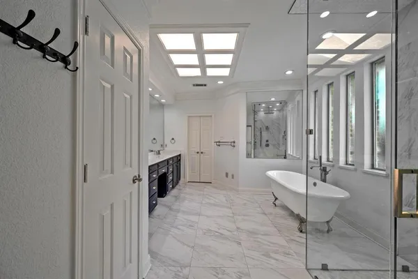 a spacious bathroom with a double vanity sink a mirror and a shower