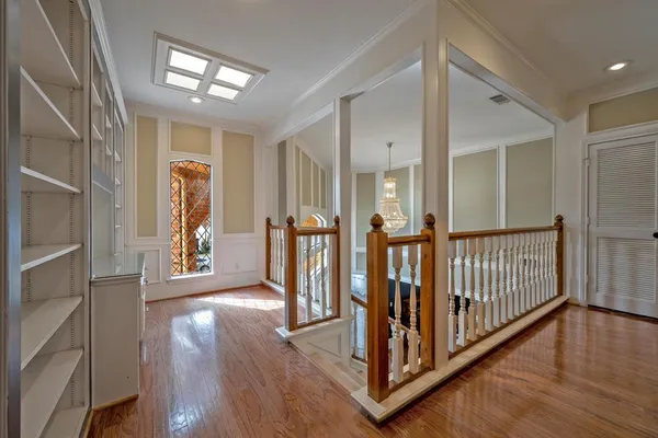 a view of a hallway with wooden floor and stairs