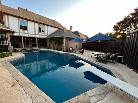 a view of a patio with table and chairs with wooden floor and fence