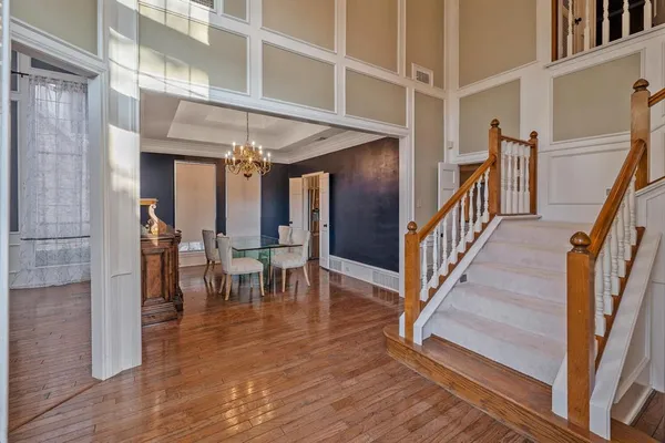 a view of a hallway with wooden floor and staircase