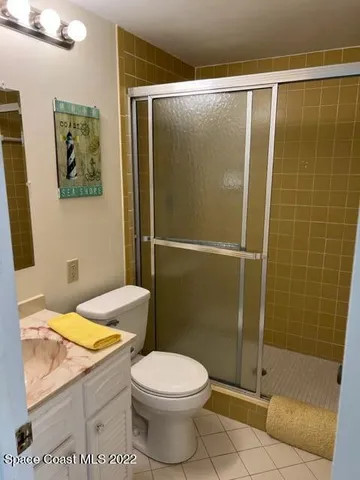 a bathroom with a granite countertop toilet a sink and shower
