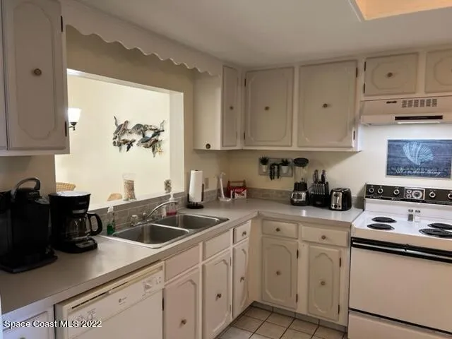 a kitchen with cabinets appliances a sink and a counter top